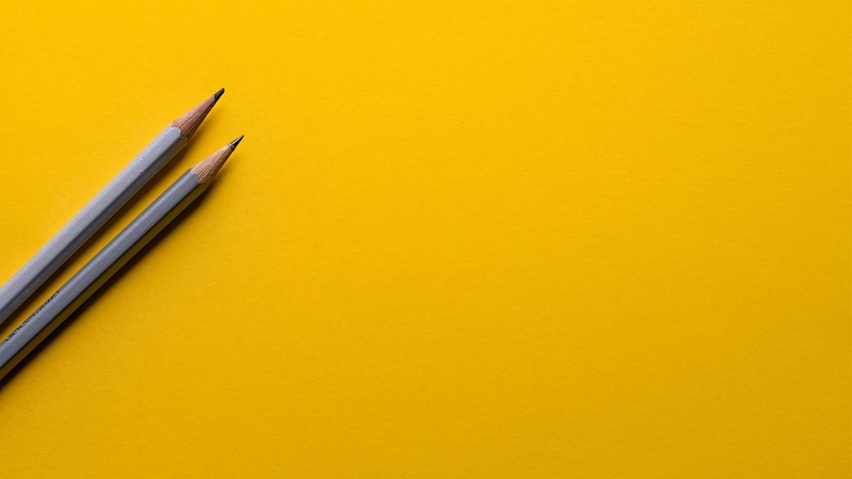 Zwei Bleistifte auf gelbem Hintergrund