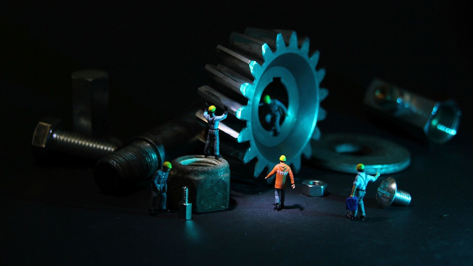 Miniatur von Ingenieuren, die Zahnräder überprüfen