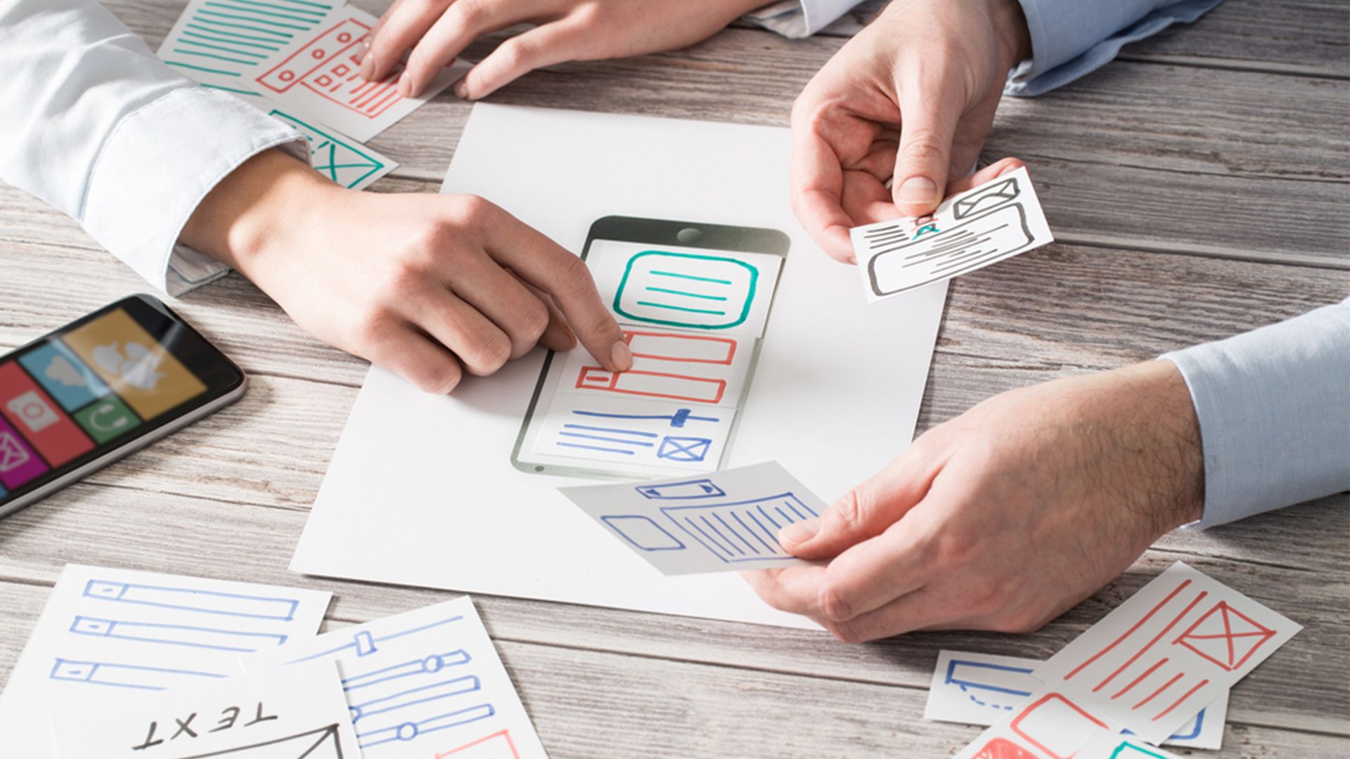 Personen schauen sich einen Entwurf in einem Meeting an.