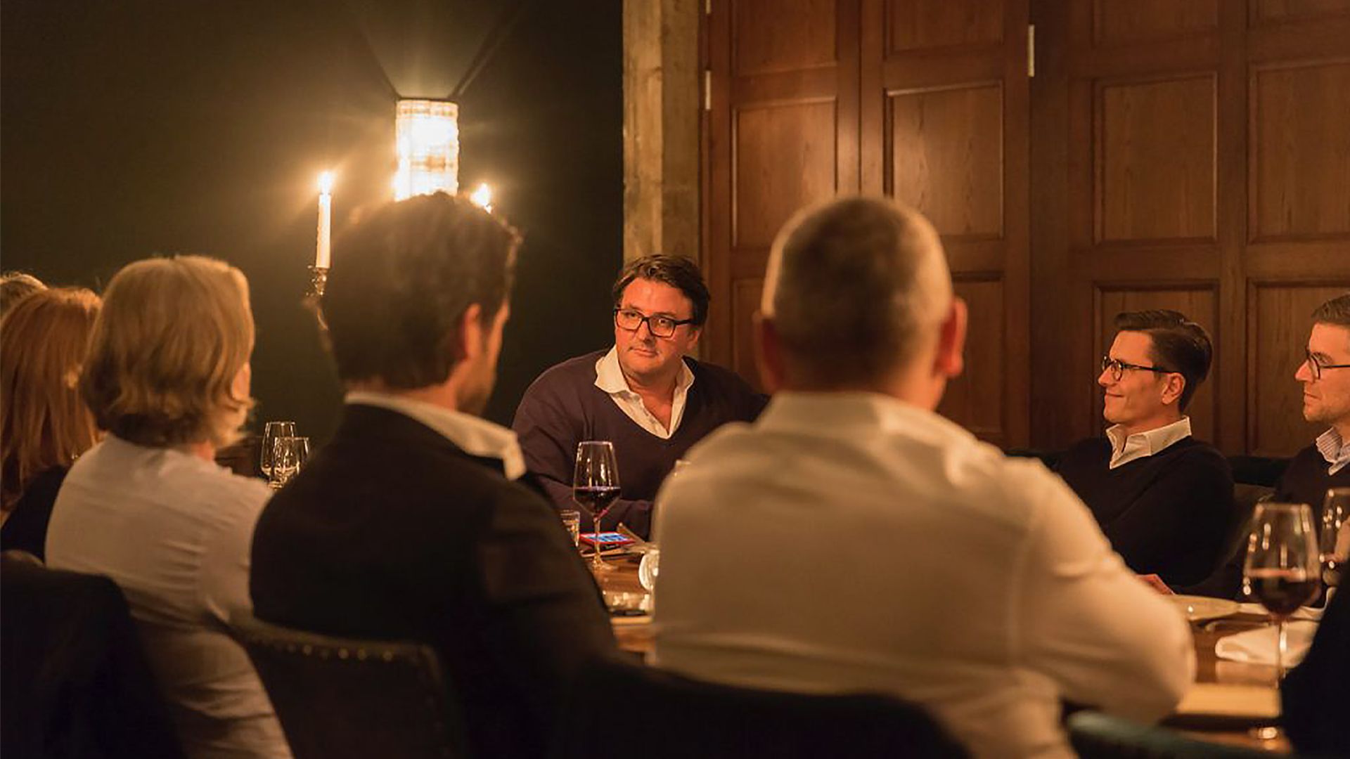 Mehrere Personen im Gespräch beim Abendessen.