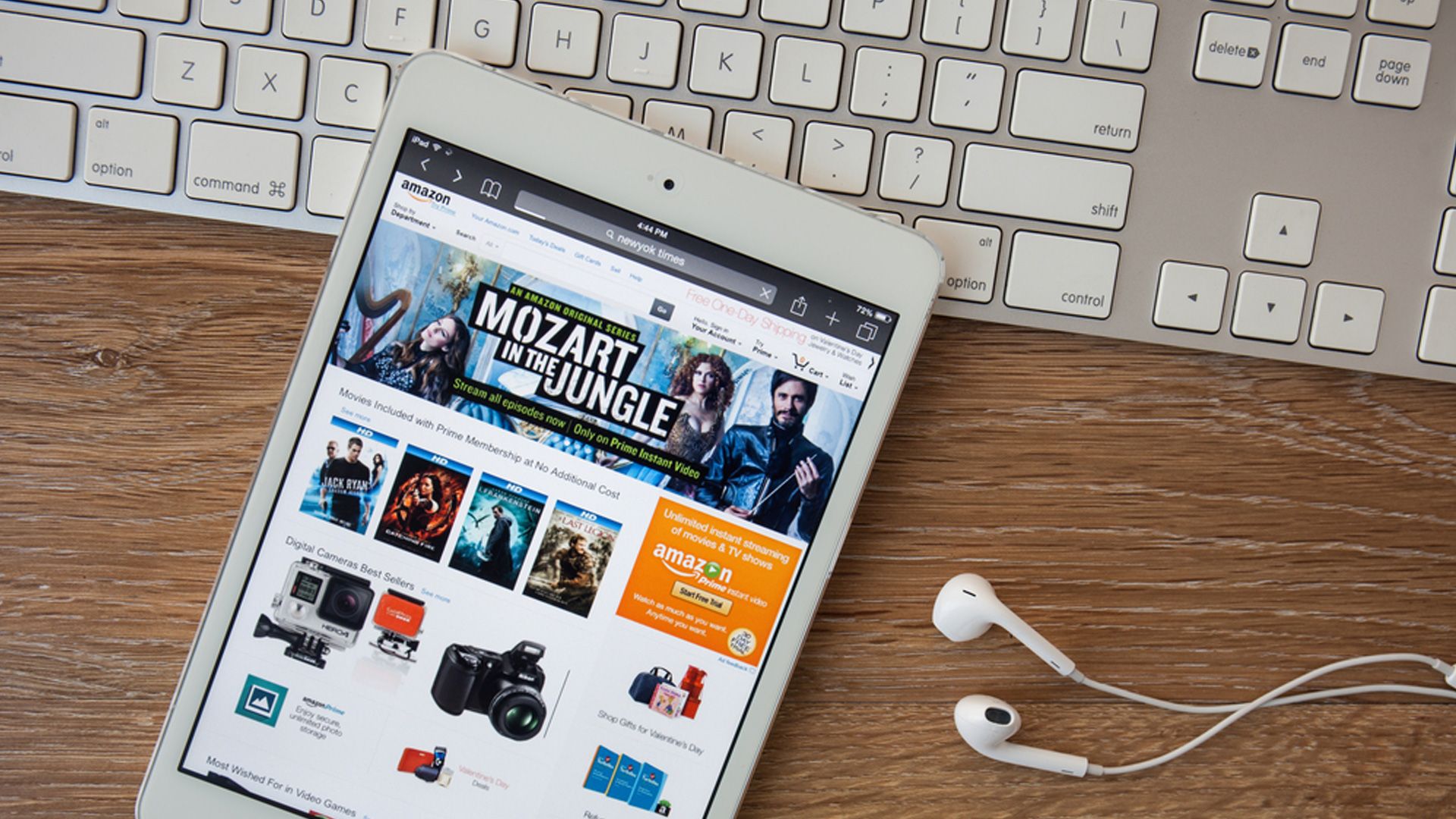 Ein Tablet liegt auf einer Tastatur, Amazon ist geöffnet -  daneben liegen Kopfhörer
