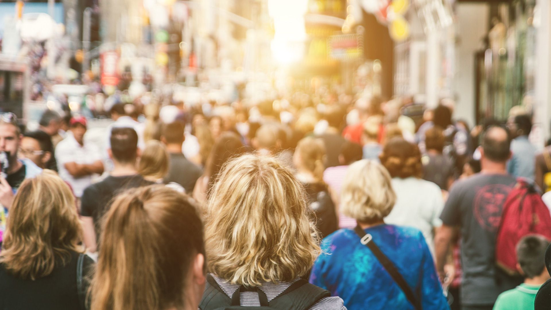 Crowd in a big city with sunset in the background